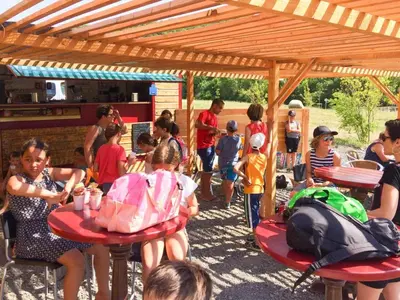 a group of children sitting at tables under a pavilion at Holiday Home in Quillan near Pyrenees in Quillan
