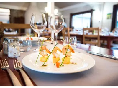 a plate of food on a table with wine glasses at Holiday Home in Quillan near Pyrenees in Quillan