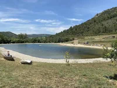 a person sitting in a chair next to a lake at Holiday Home in Quillan near Pyrenees in Quillan