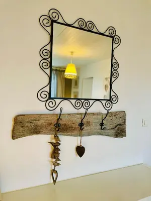 a mirror hanging on a wall with a piece of wood and a wooden stick at Chambres d'hôtes Le Pessac in Vielmur-sur-Agout