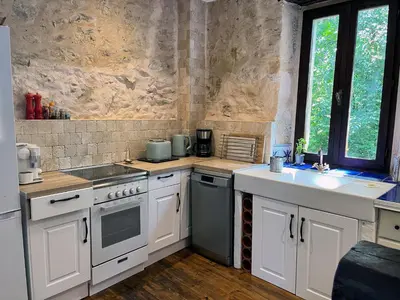 a kitchen with white cabinets and a sink and a stove at Gites de Montcabirol in Mirepoix