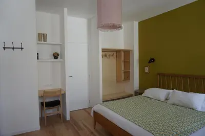 a bedroom with a bed and a green wall at midi03 in Carcassonne