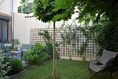 a garden with a fence and a chair and a tree at midi03 in Carcassonne