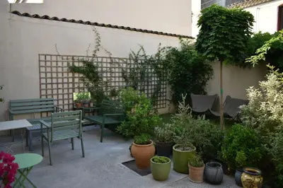 a patio with tables and chairs and potted plants at midi03 in Carcassonne