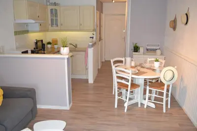 a kitchen and a living room with a table and chairs at L'instant Canal in Capestang