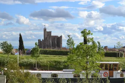 a train in front of a castle in a field at L'instant Canal in Capestang