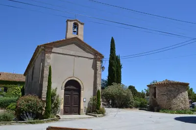 a small church with a tower and a door at L'instant Canal in Capestang