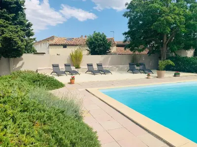 a swimming pool with lounge chairs next to a house at Maison de Margot in Peyriac-Minervois