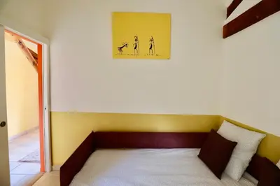 a bed in a room with a picture on the wall at Maison de Margot in Peyriac-Minervois