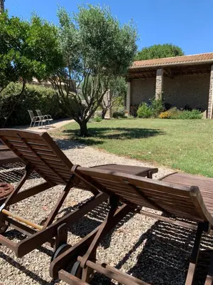 a wooden bench sitting in the middle of a yard at Maison de Margot in Peyriac-Minervois