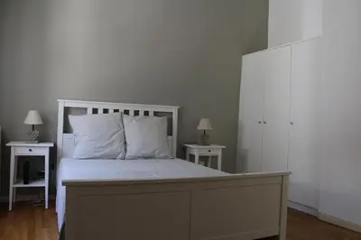 a bedroom with a white bed with two night stands at La Folie des Remparts in Carcassonne