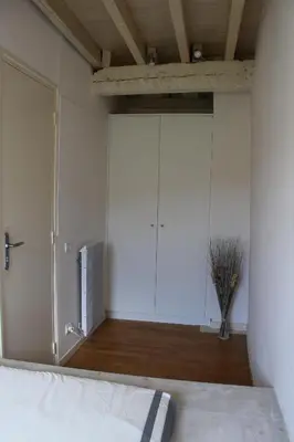 a bedroom with white cabinets and a bed at La Folie des Remparts in Carcassonne