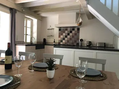 a kitchen with a wooden table with wine glasses at La Folie des Remparts in Carcassonne