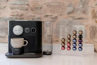 a coffee maker with a cup and a box of donuts at Domaine de Merlac in Rieussec