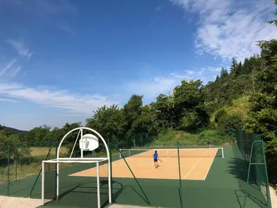 two people playing tennis on a tennis court at Domaine de Merlac in Rieussec
