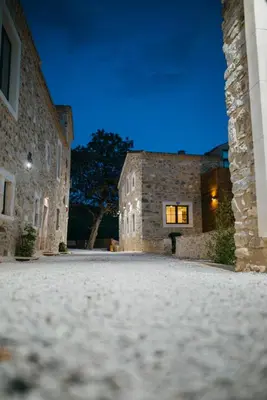 an empty courtyard of a stone building at night at Domaine de Merlac in Rieussec