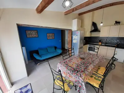 a kitchen with a table and a blue couch at Lotus in Cébazan
