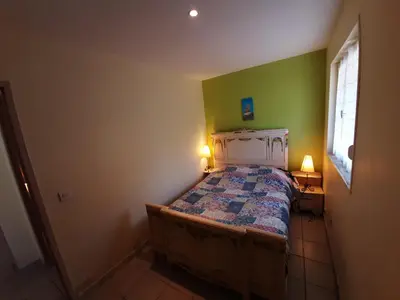 a small bedroom with a bed and a green wall at Lotus in Cébazan