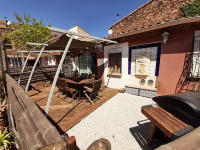 a porch of a house with a bench and a grill at Lotus in Cébazan