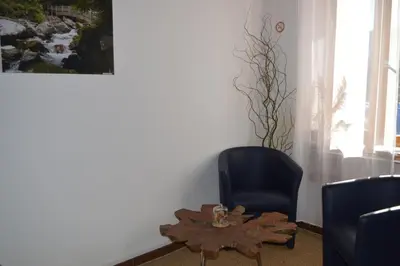 a living room with a table and a chair and a picture at El roble in LʼAiguillon