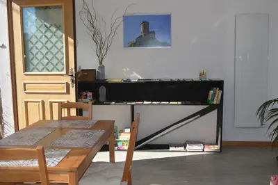 a living room with a table and a piano at El roble in LʼAiguillon