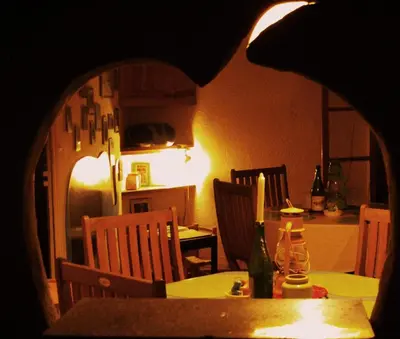 a dining room with a table and chairs and a kitchen at Mini-Hôtel de Camps in Camps-sur-lʼAgly