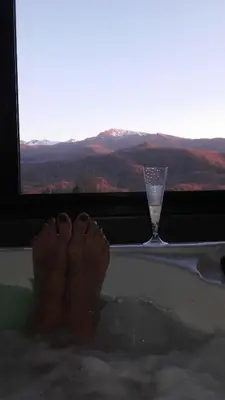 a persons feet in a bath tub with a glass of wine at Gites du pech cathare in Leychert
