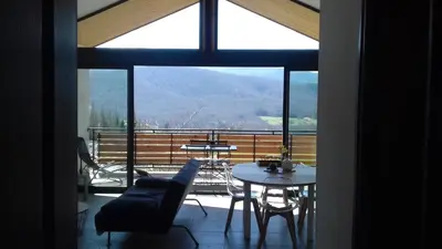 a living room with a table and chairs and a large window at Gites du pech cathare in Leychert