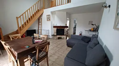 a living room with a blue couch and a table at gite echarou agréable maison de famille in Sigean