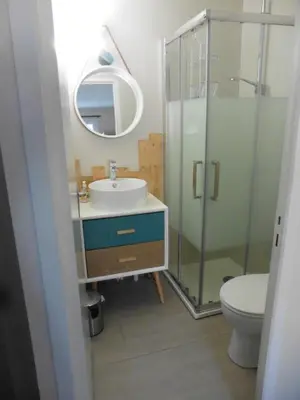 a bathroom with a sink and a toilet and a mirror at gite echarou agréable maison de famille in Sigean