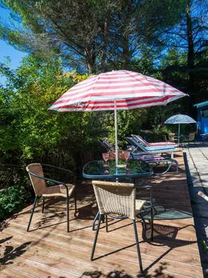 a table and chairs with an umbrella on a deck at Horizons Verts Appartement Jasmin in Puivert