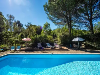 a swimming pool with chairs and umbrellas in a yard at Horizons Verts Appartement Jasmin in Puivert
