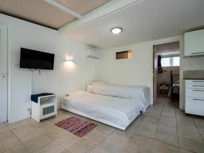 a bedroom with a bed and a flat screen tv at Horizons Verts Appartement Jasmin in Puivert