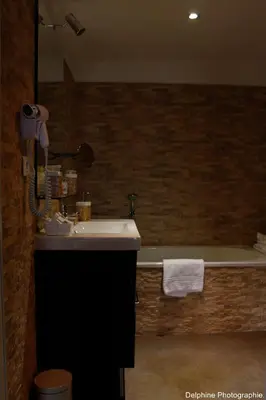 a bathroom with a sink and a bath tub at Maison d'hôtes 