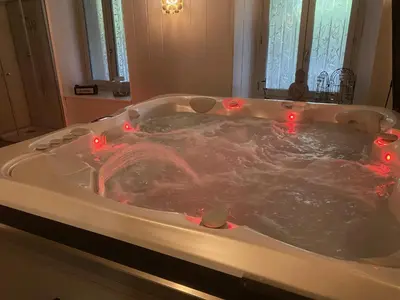a bath tub with red lights in it at Maison d'hôtes 