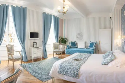 a bedroom with a bed and a chair and a couch at Maison d'hôtes 