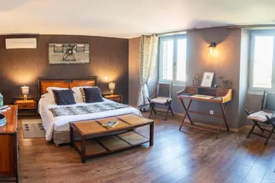 a bedroom with a bed and a table in a room at Maison d'hôtes 
