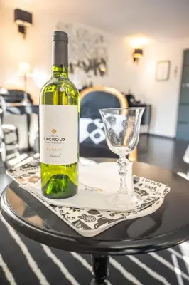 a bottle of wine and a glass on a table at Maison d'hôtes 