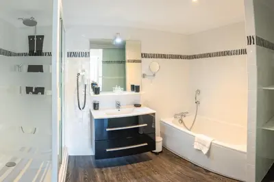 a bathroom with a tub and a sink and a bath tub at Maison d'hôtes 