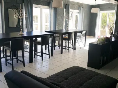 a dining room with two tables and chairs and a couch at La Pinède D'Estarac in Bages