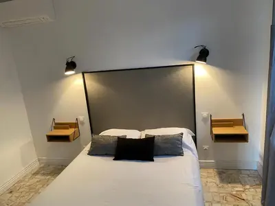 a bedroom with a bed and a television and a window at MAISON MIGNARDISE - Cité in Carcassonne