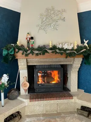 a fireplace with a christmasreath on top of it at MAISON MIGNARDISE - Cité in Carcassonne