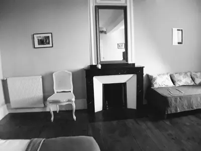 a living room with a chair and a mirror at L'affable Les cammazes in Les Cammazes