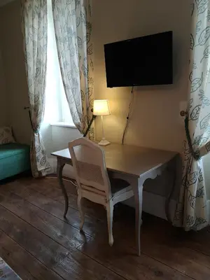 a room with a desk with a chair and a television at L'affable Les cammazes in Les Cammazes