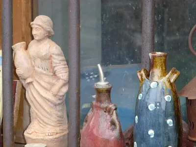 a statue of a man standing next to two vases at Chambre d'Hôtes la Poterie in Caunes-Minervois