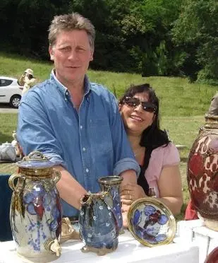 a man and a woman sitting at a table with vases at Gite Le Lavoir - La Poterie in Caunes-Minervois