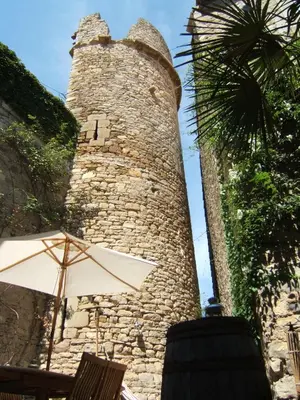 an umbrella sitting in front of a tall tower at Gite la Tour in Pépieux