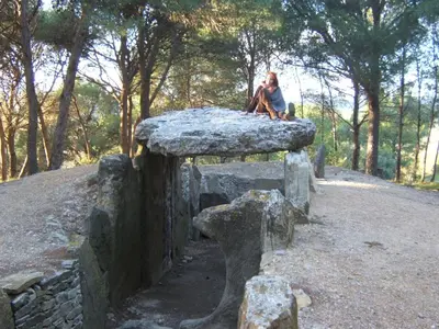 a person sitting on top of a stone bench at Gite la Tour in Pépieux
