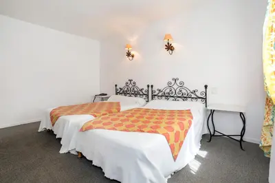 two beds in a room with white walls at Logis Hôtels - Hôtel Restaurant du Midi in Revel
