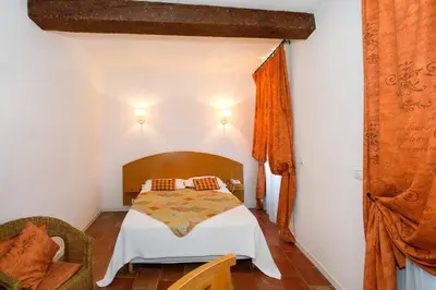 a bedroom with a bed in a room at Logis Hôtels - Hôtel Restaurant du Midi in Revel